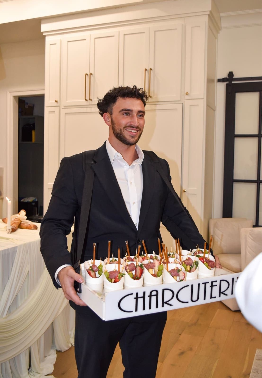 Server presenting charcuterie cups at elegant event