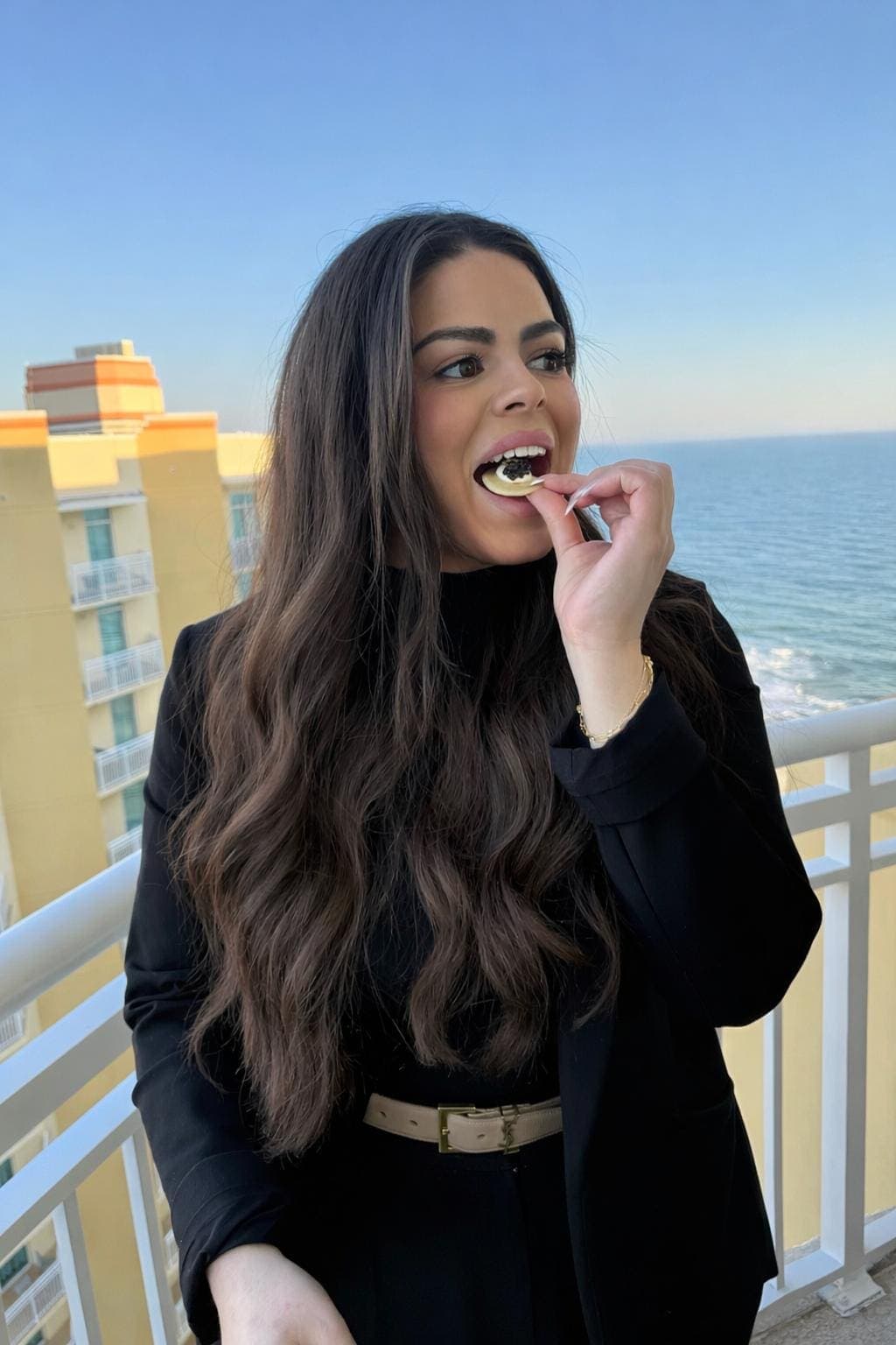 Guest enjoying caviar on a balcony overlooking the ocean