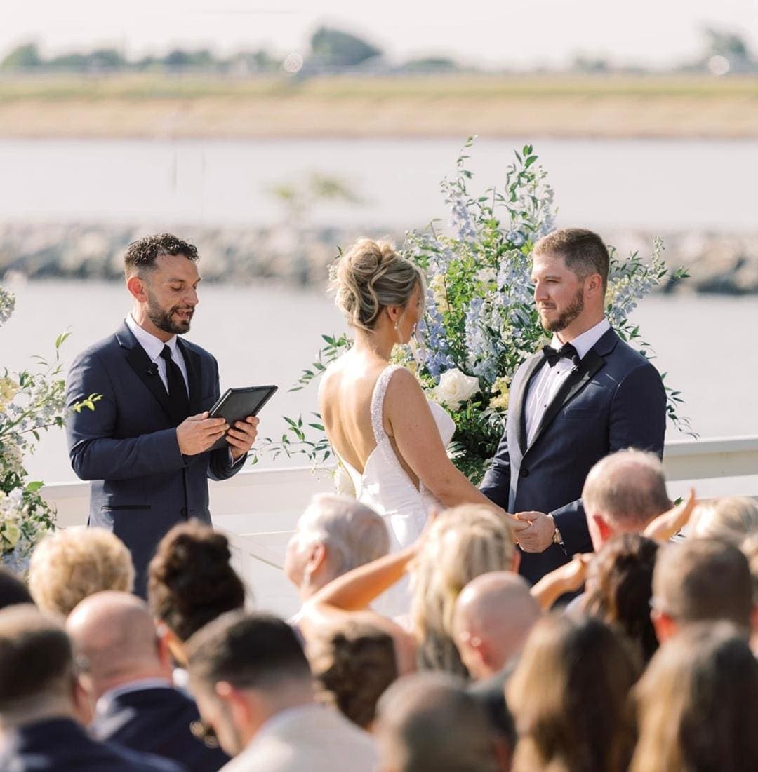 Waterfront wedding ceremony with officiant and couple