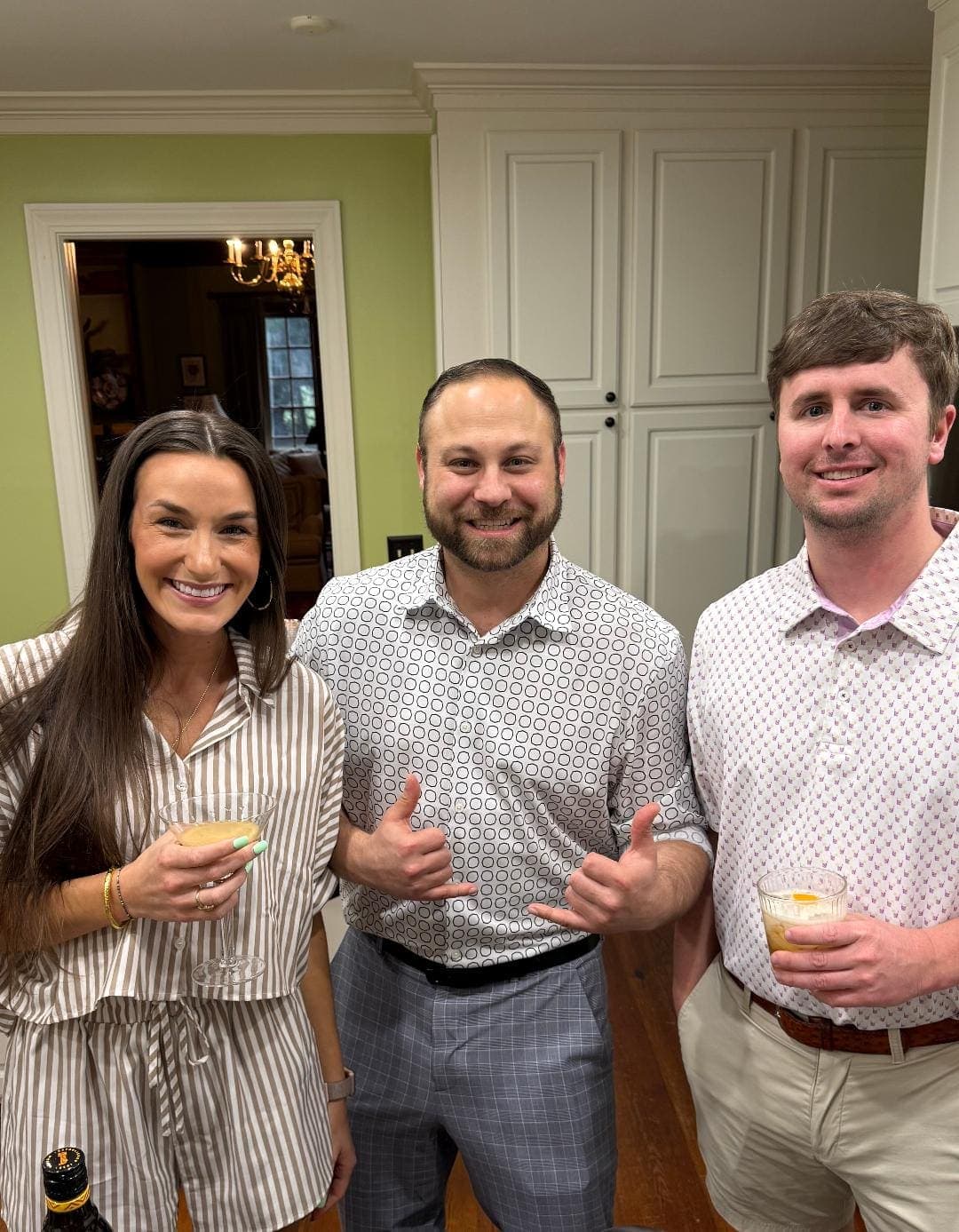 Team members with cocktails giving thumbs up