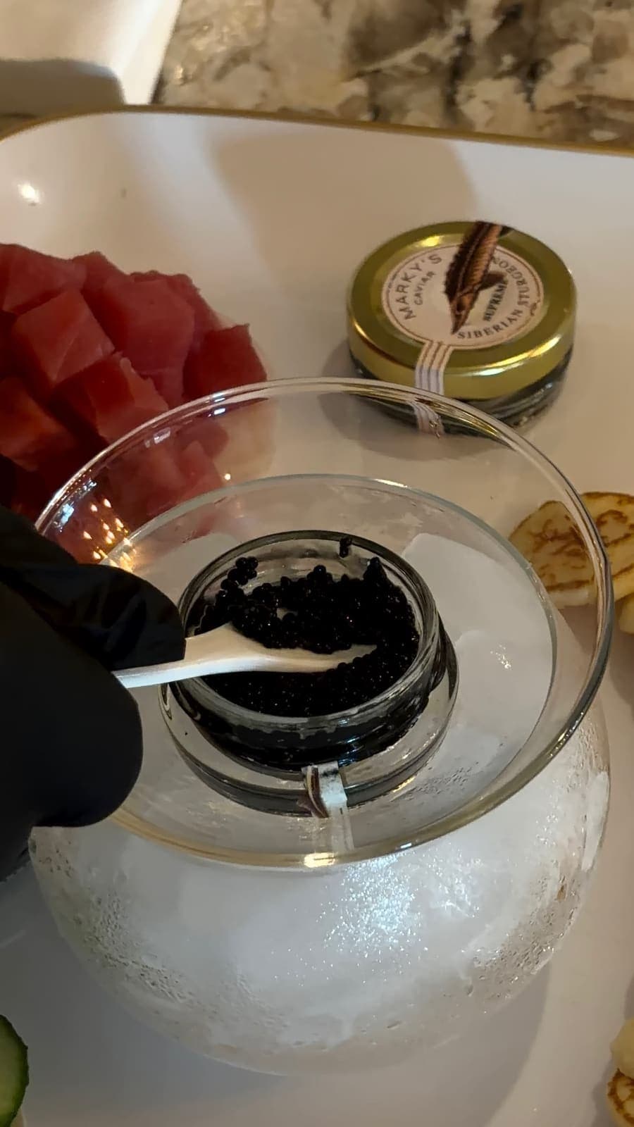 Caviar served over ice with fresh tuna and blini