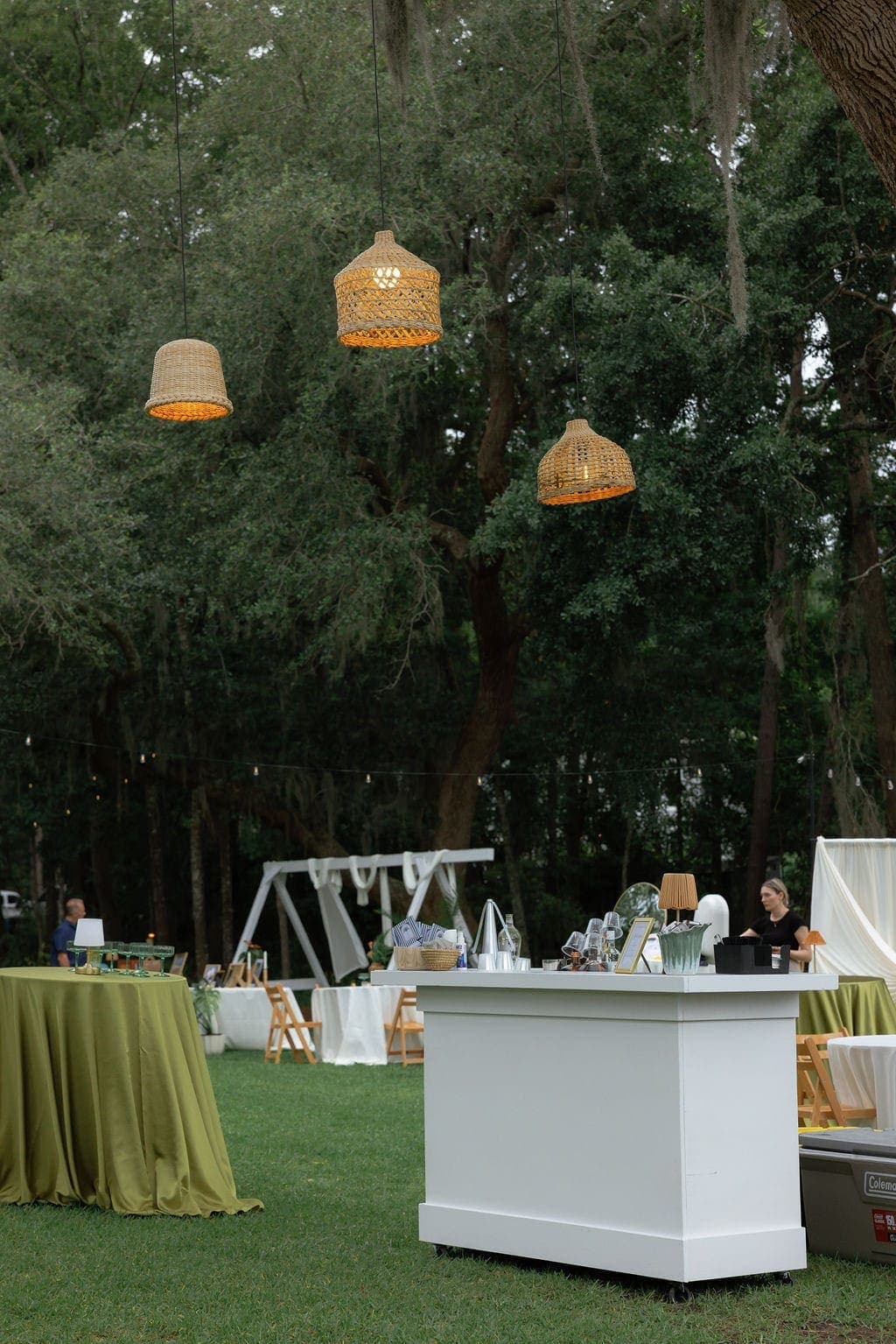 Outdoor mobile bar under oak trees with hanging rattan lanterns