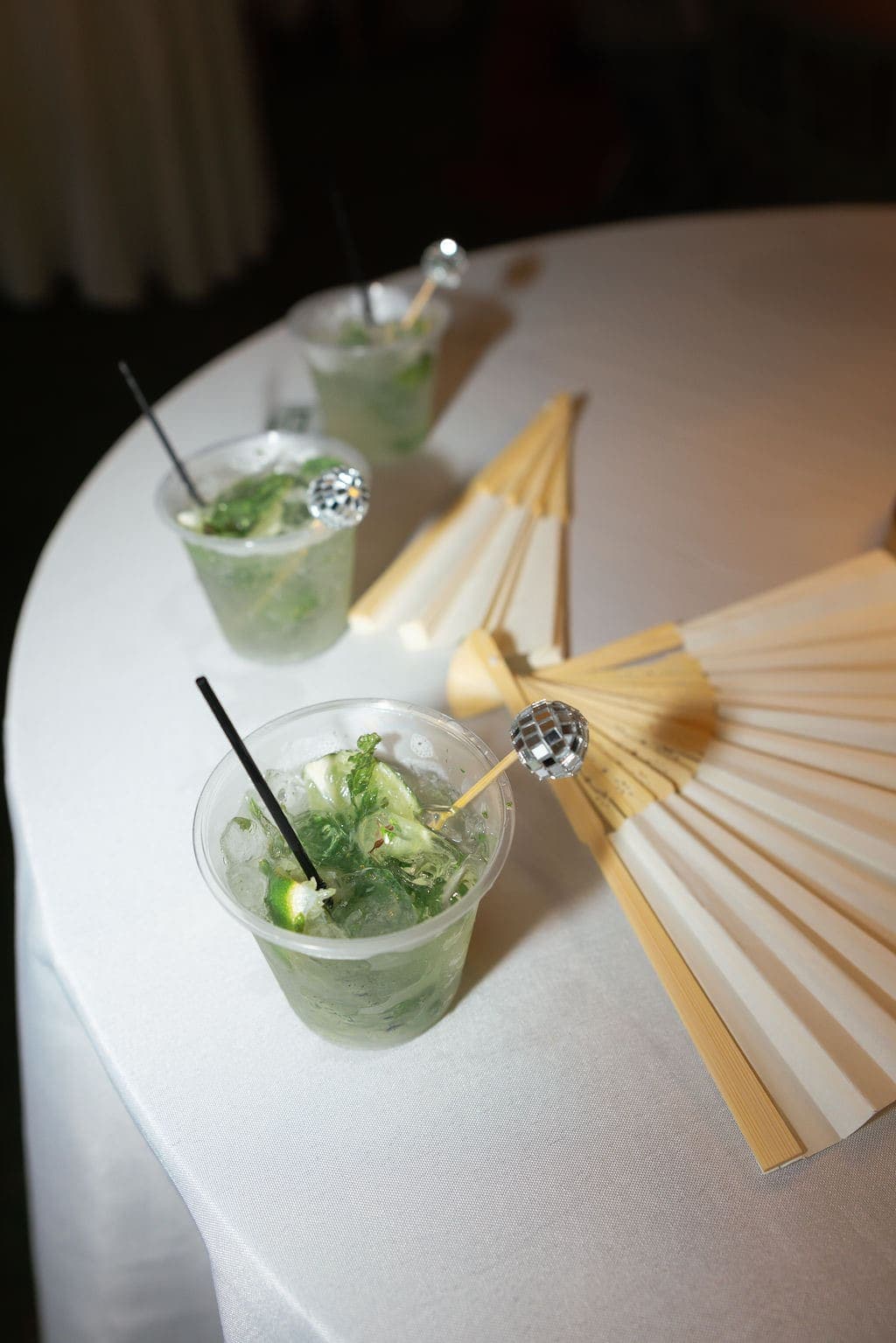 Mojitos garnished with disco-ball stirrers on a cocktail table
