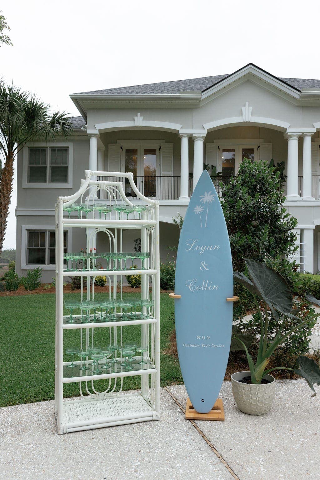 Champagne coupe display beside a custom surfboard wedding sign