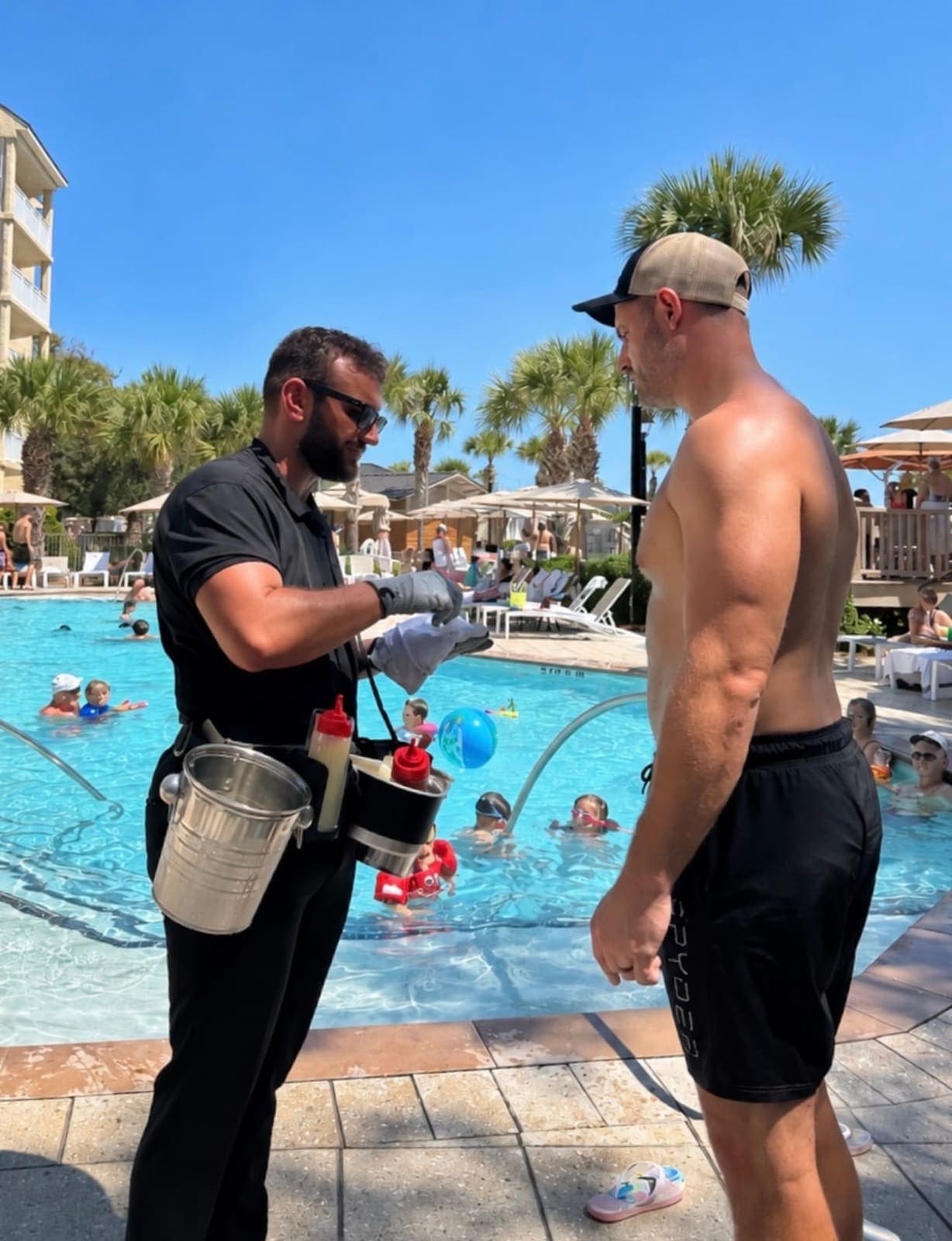 Oyster attendant serving a guest poolside from the roaming oyster belt