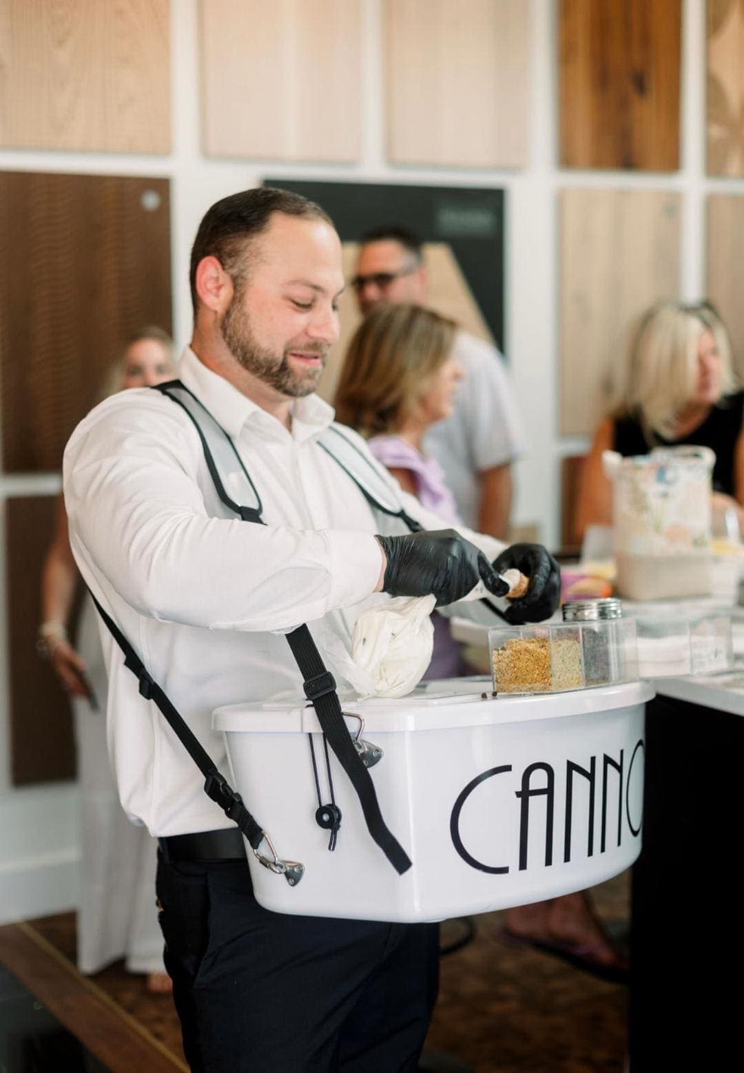 Branded cannoli attendant piping a fresh cannoli to order for guests at an event