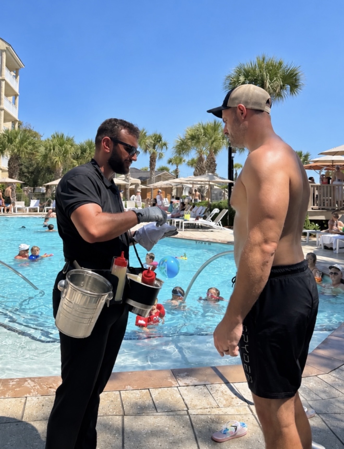Oyster attendant serving a guest poolside from the roaming oyster belt